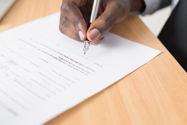 A man signing a document on a table